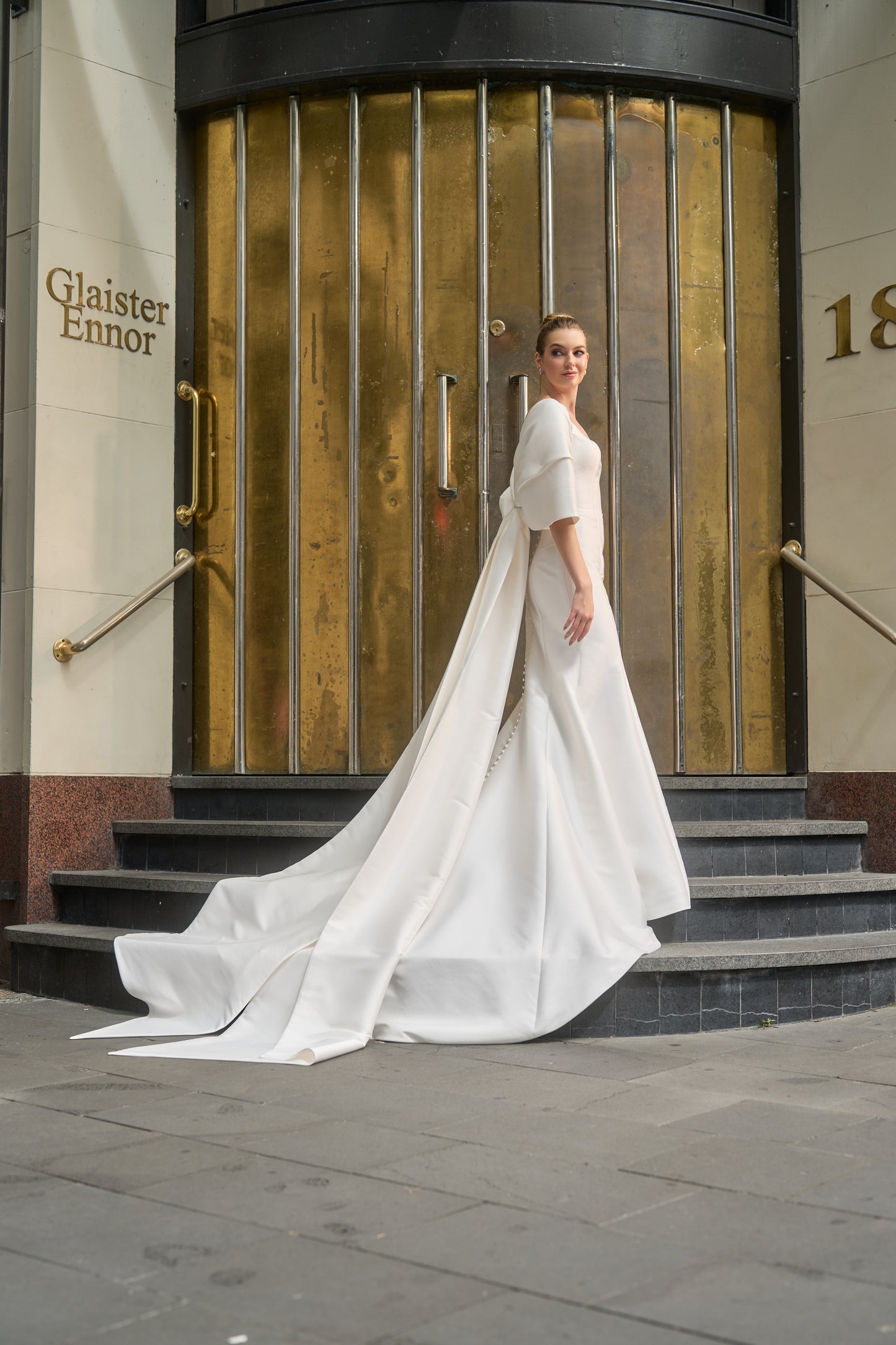 side view of Ricci Bow wraps around model's arms and extends into long train