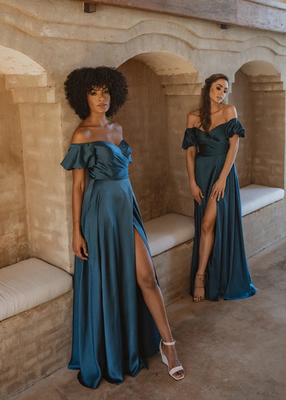 Peacock blue satin bridesmaid dresses with front split in skirt and off-the-shoulder puff sleeves.