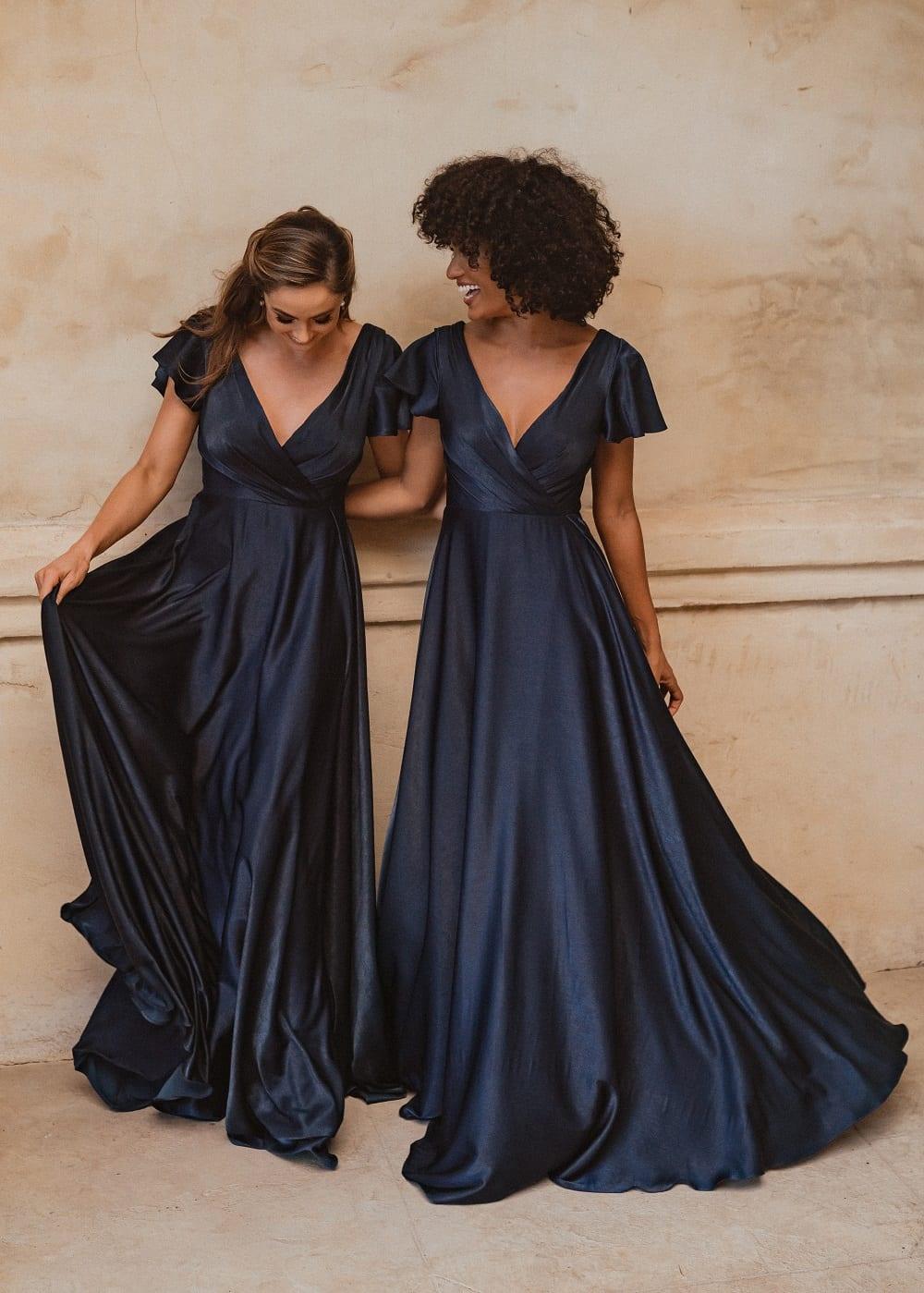 Auckland bridesmaid dress in midnight blue satin. Cross over neckline to waist with flared short sleeves and full length skirt