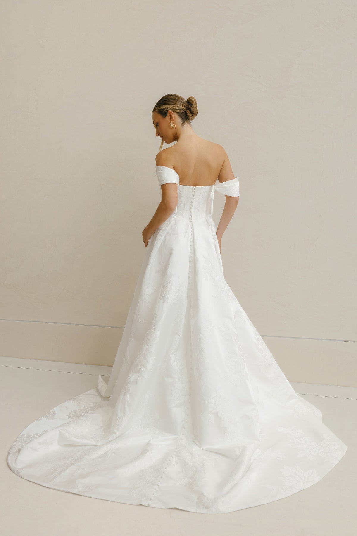 A-line wedding gown in Floral Jacquard fabric, off-the-shoulder sleeves, pleated skirt. 