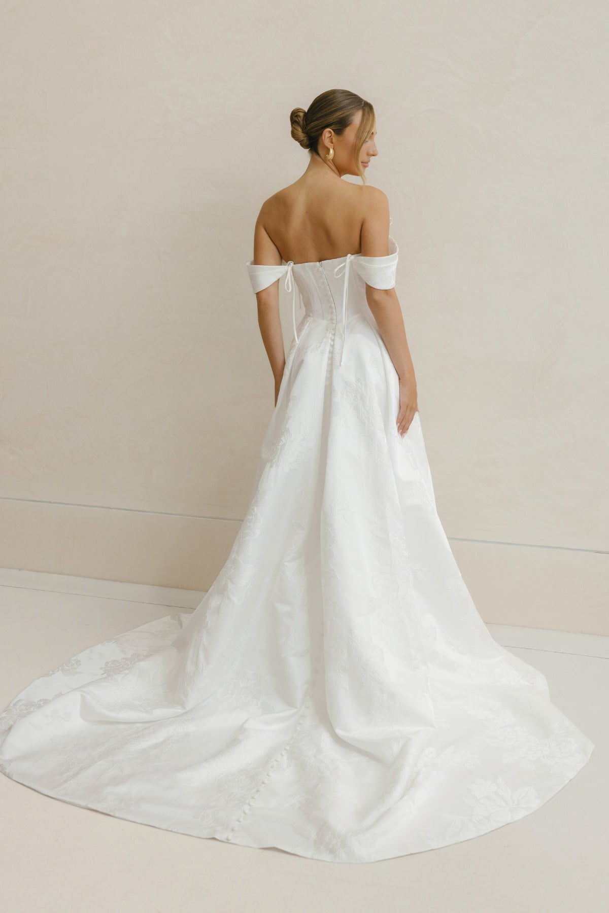 A-line wedding gown in Floral Jacquard fabric, off-the-shoulder sleeves, pleated skirt. 
