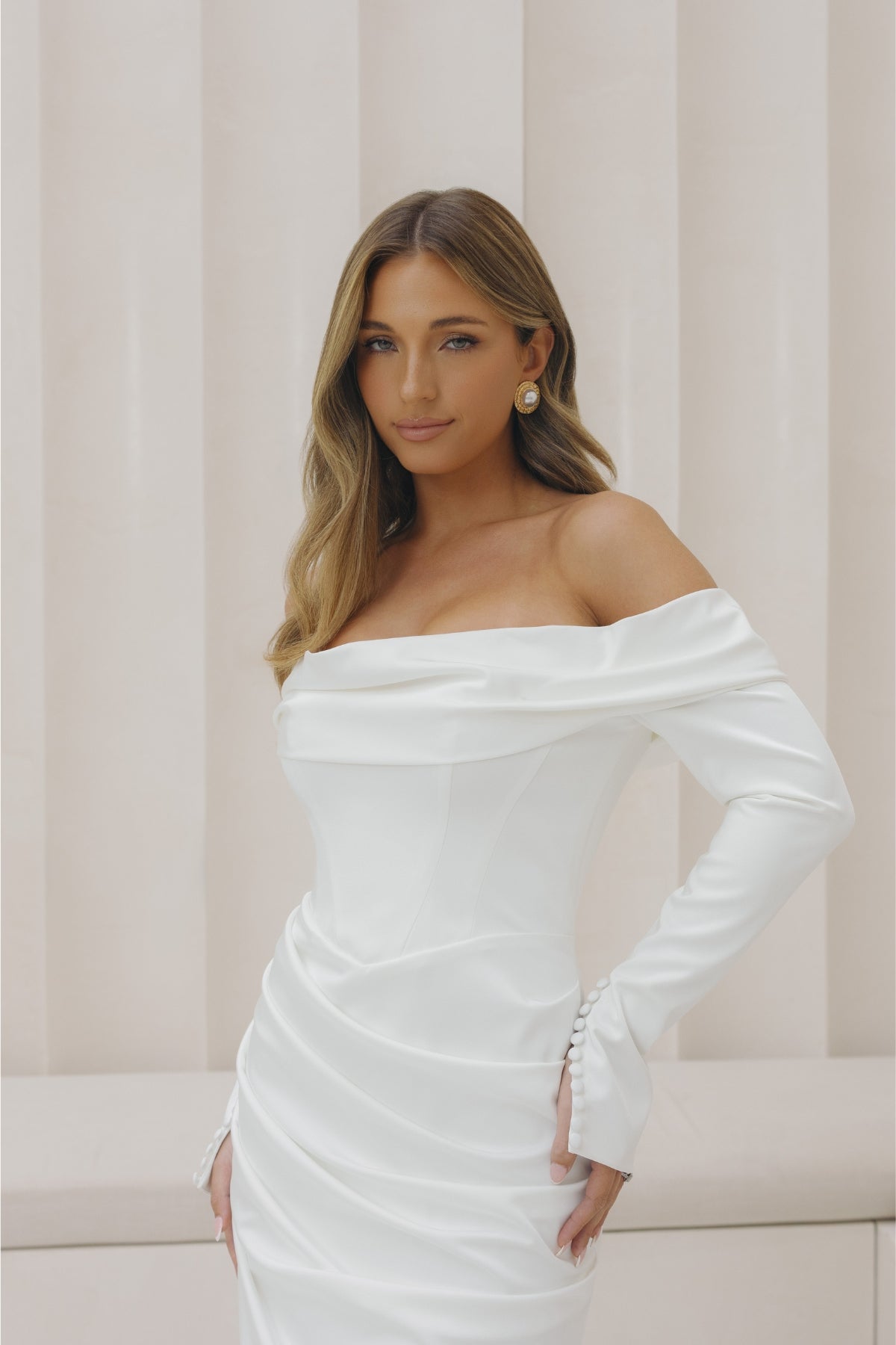 Satin fitted gown with off the shoulder neckline and long sleeves. 