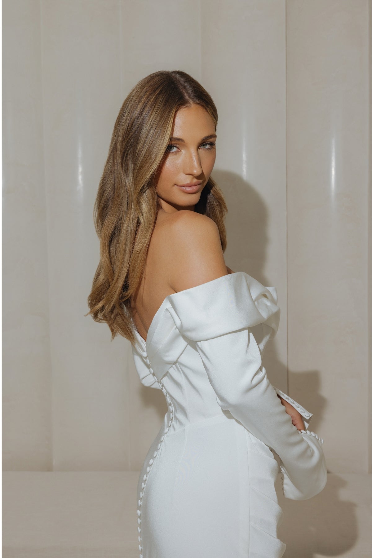 Satin fitted gown with off the shoulder neckline and long sleeves. 