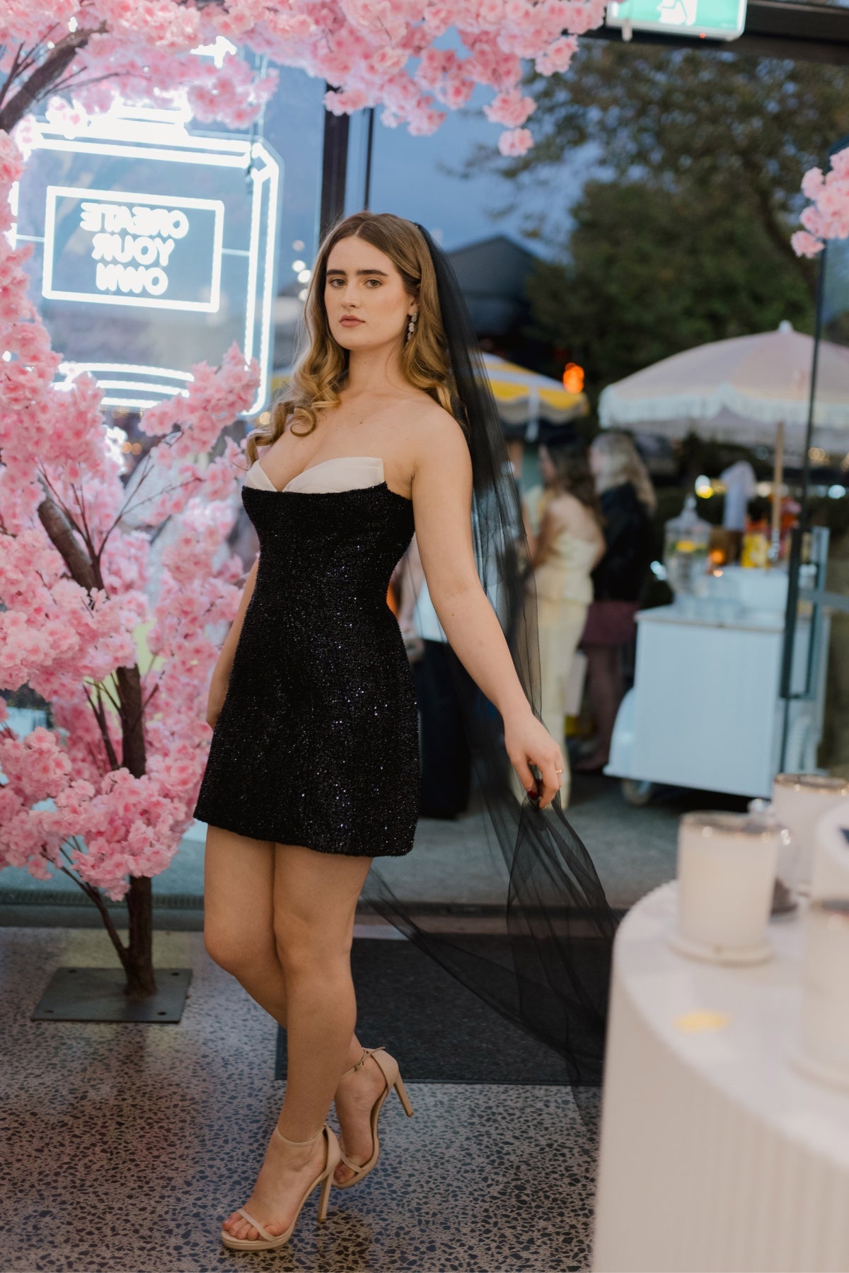 Fitted, sparkly black mini dress with ivory cups peeking through the bodice 