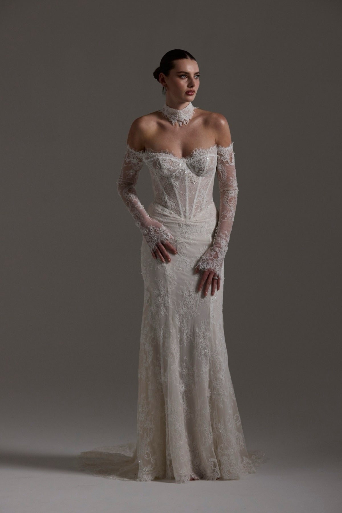 Fitted wedding gown featuring off-the-shoulder sleeves and neckline, vintage chantilly lace, basque waist, and lace choker. 