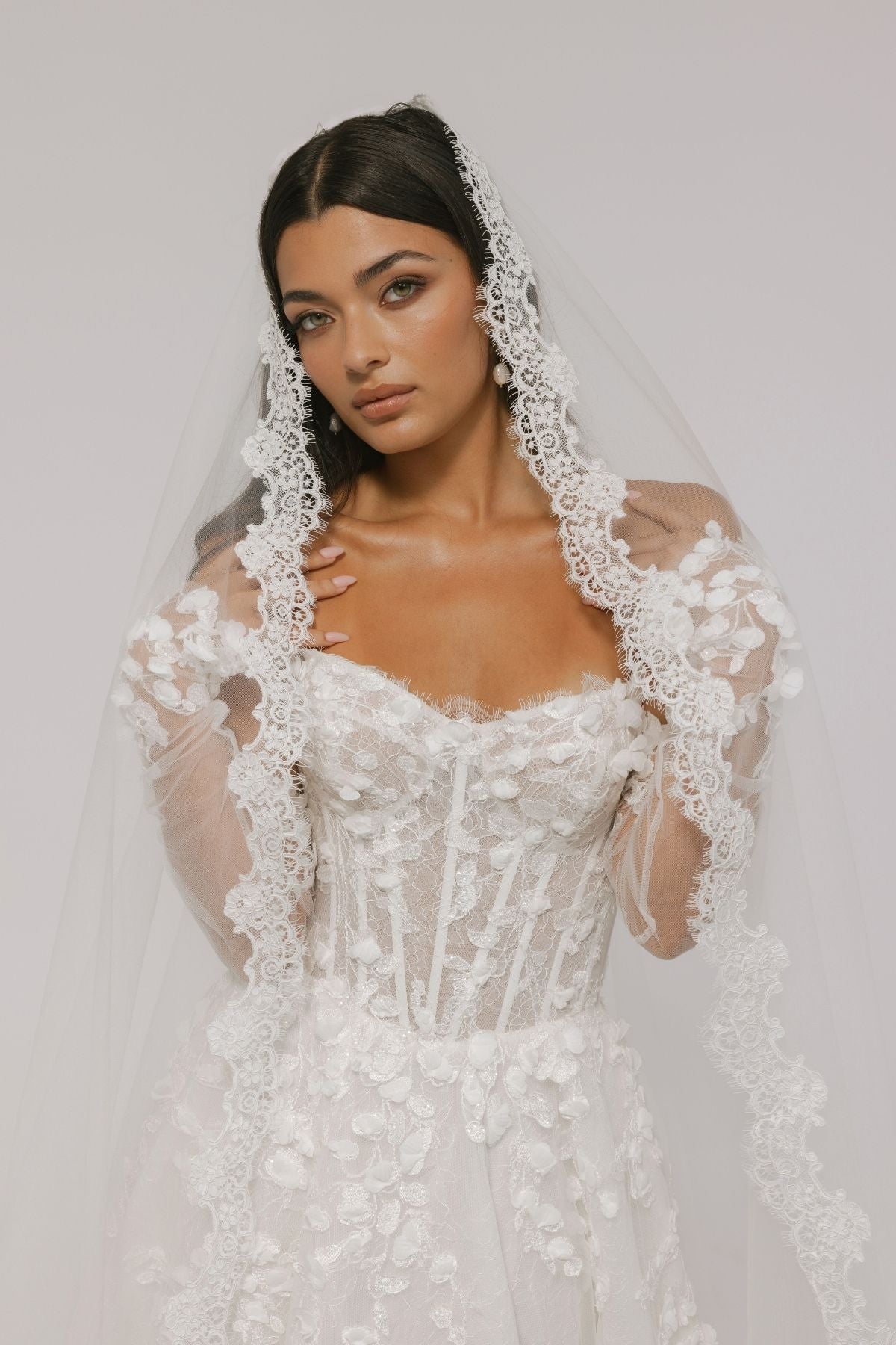bride wears an elegant mantilla lace veil
