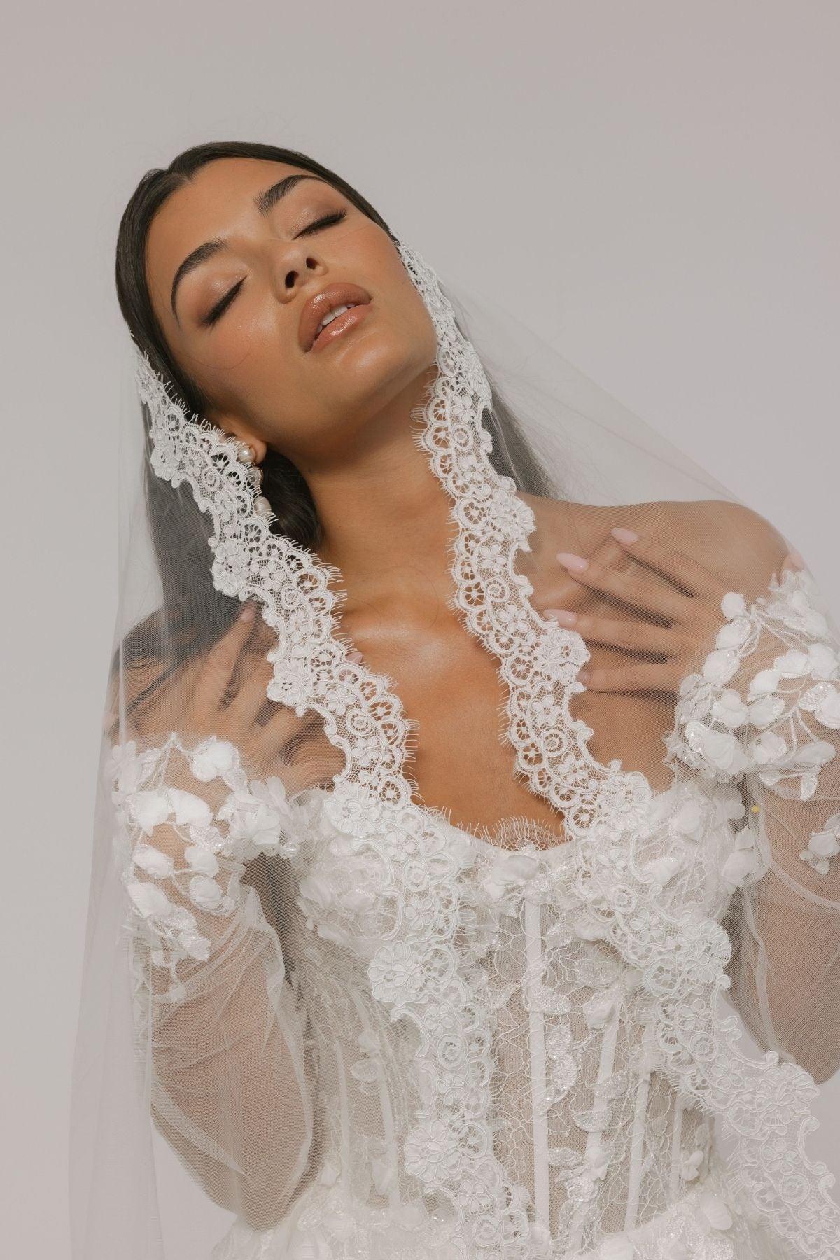 bride wears an elegant mantilla lace veil
