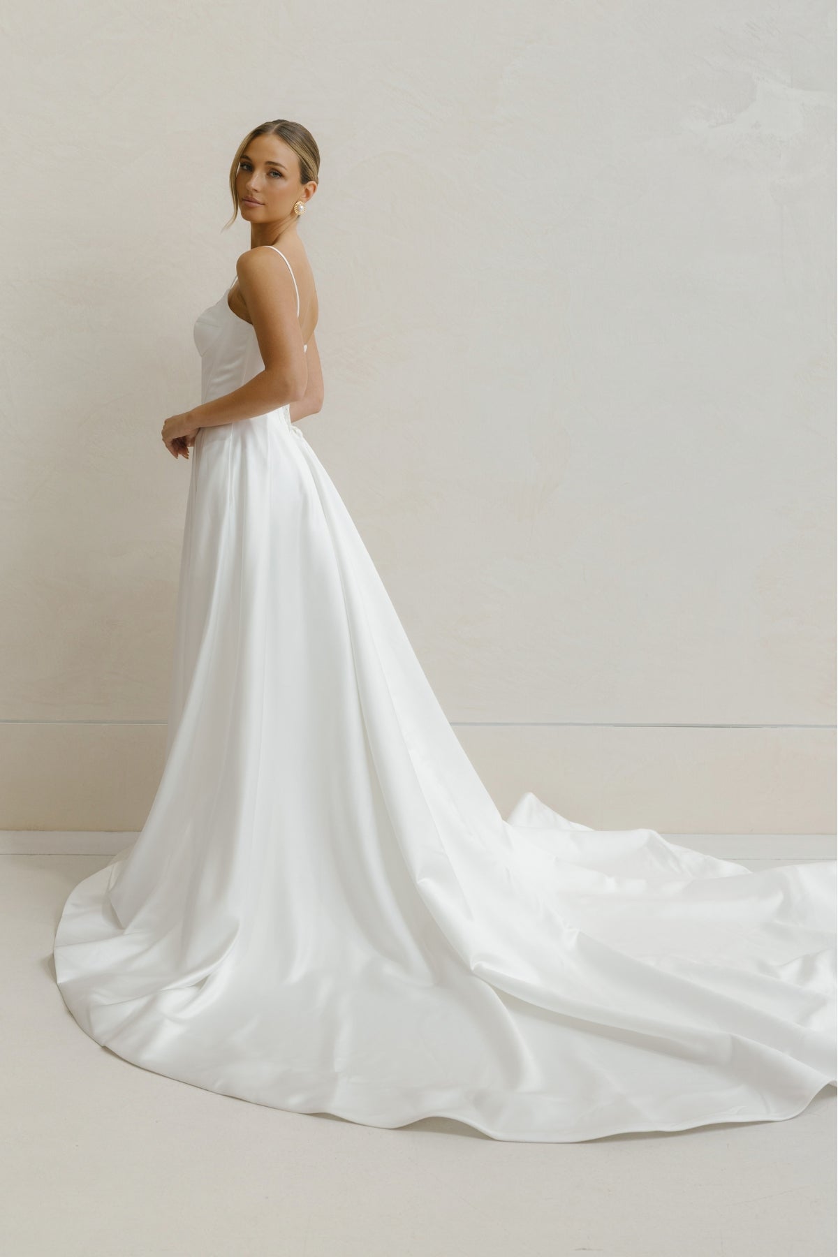 A-line Wedding gown in Satin, thin shoulder straps, corseted bodice with basque waistline. 