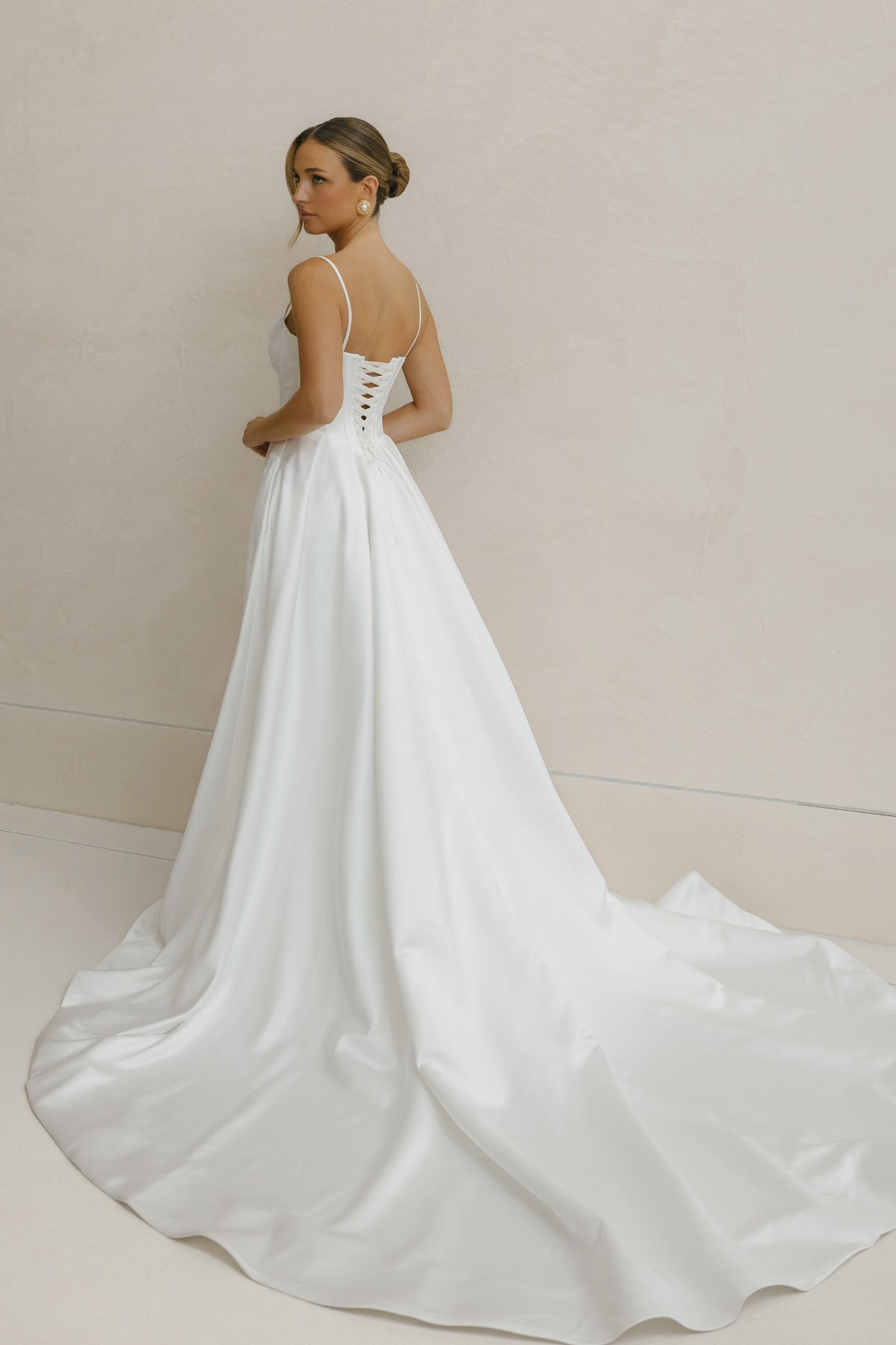 A-line Wedding gown in Satin, thin shoulder straps, corseted bodice with basque waistline. 