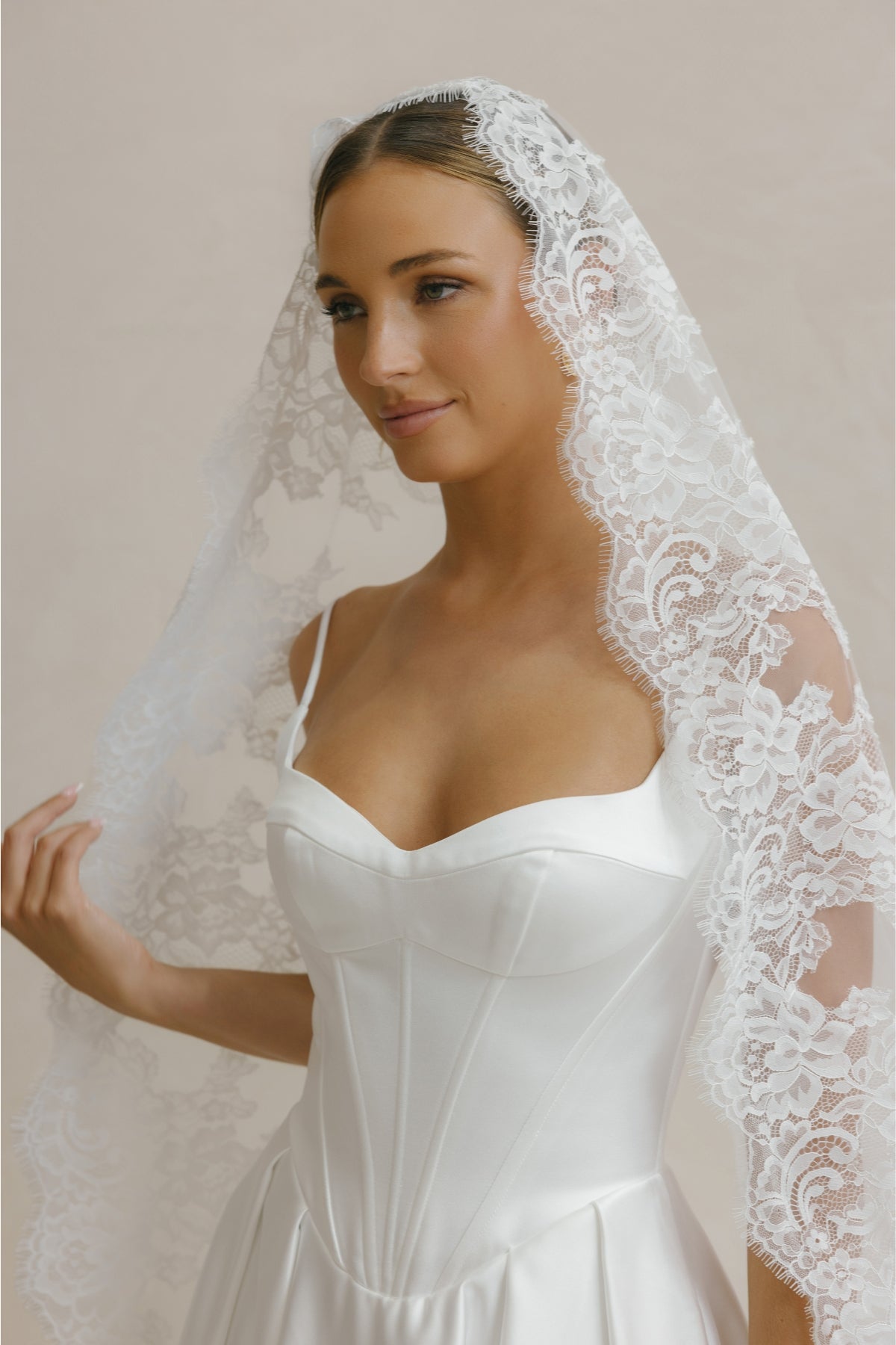A-line Wedding gown in Satin, thin shoulder straps, corseted bodice with basque waistline. 