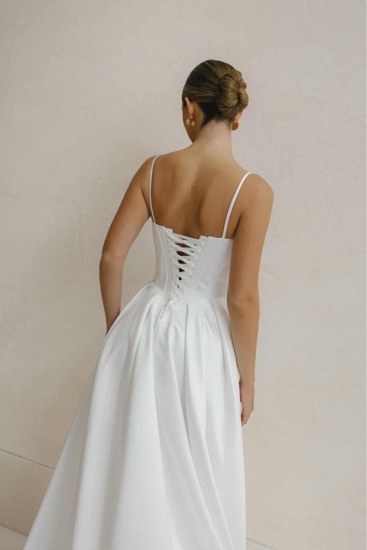 A-line Wedding gown in Satin, thin shoulder straps, corseted bodice with basque waistline. 