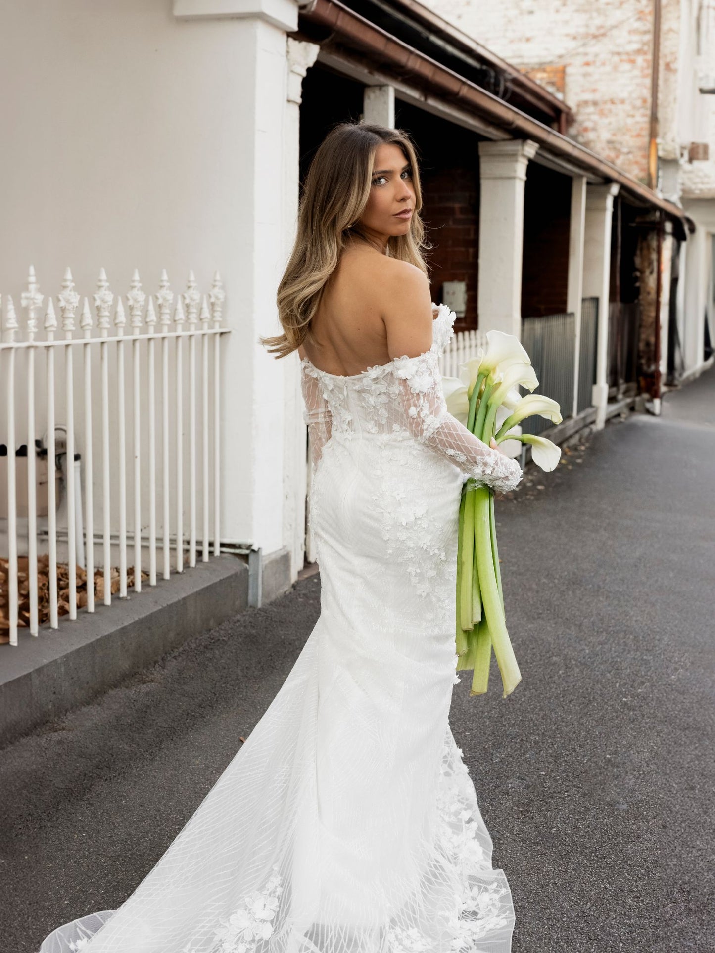 FION Bridal Gown by Windsor Collection Jessica Couture. Fit-n-Flare gown with strapless neckline, fitted gloves, and beaded floral lace. 