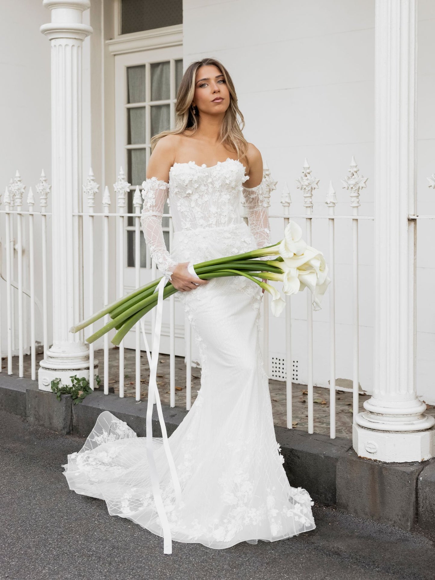 FION Bridal Gown by Windsor Collection Jessica Couture. Fit-n-Flare gown with strapless neckline, fitted gloves, and beaded floral lace. 