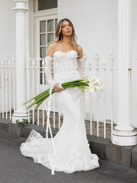 FION Bridal Gown by Windsor Collection Jessica Couture. Fit-n-Flare gown with strapless neckline, fitted gloves, and beaded floral lace. 