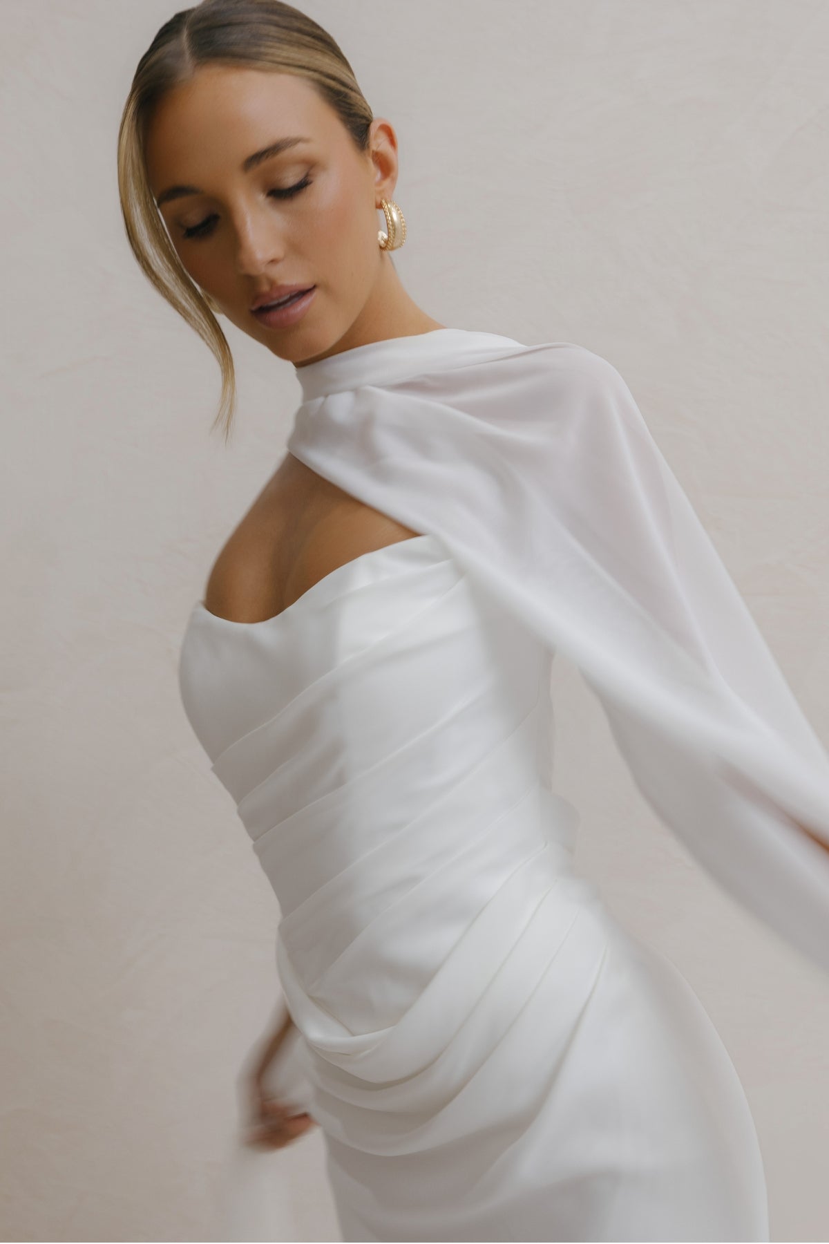 fitted crepe Bridal gown, strapless neckline, drapings around bust and hips. Paired with a scarf 