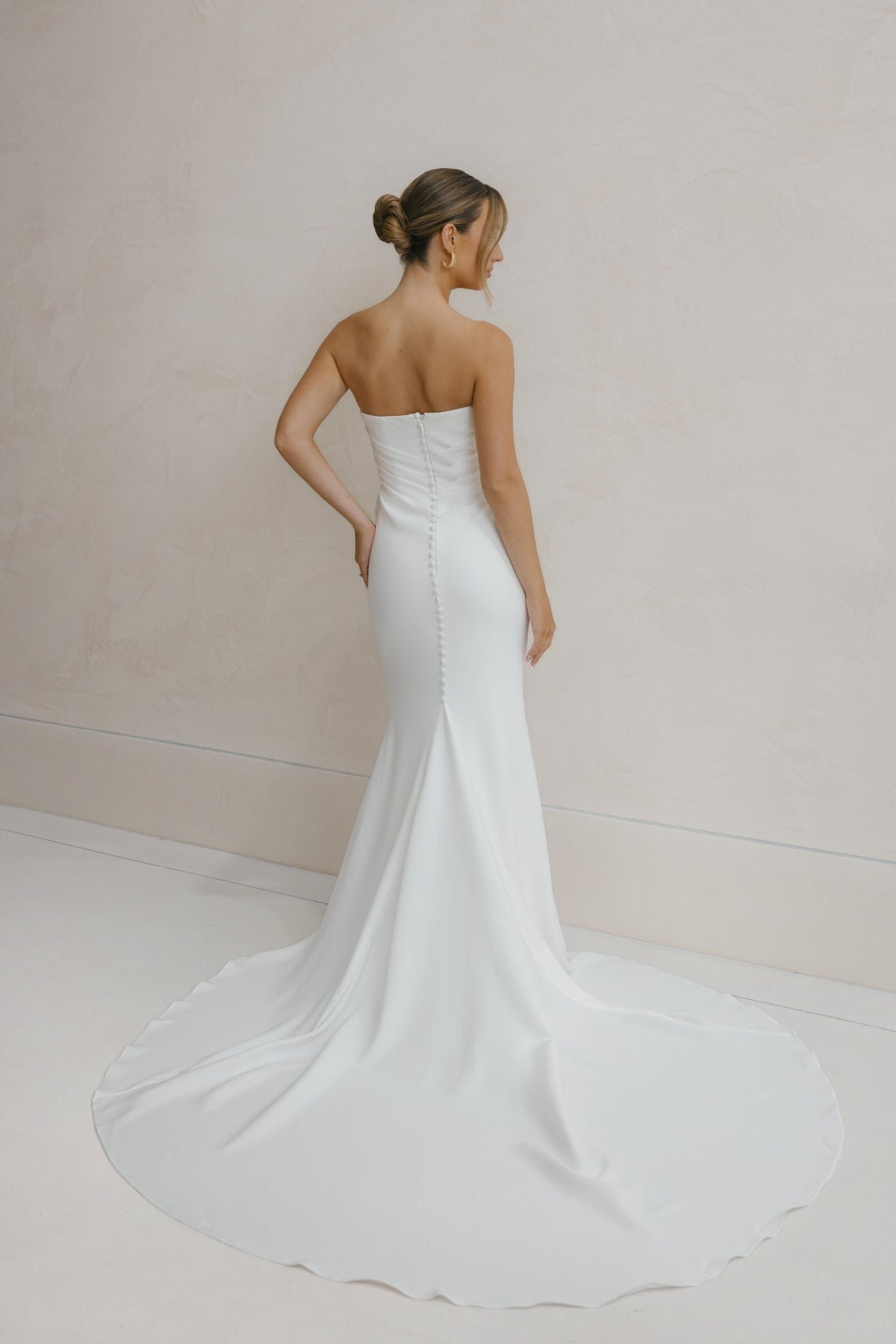 fitted crepe Bridal gown, strapless neckline, drapings around bust and hips. Paired with a scarf 