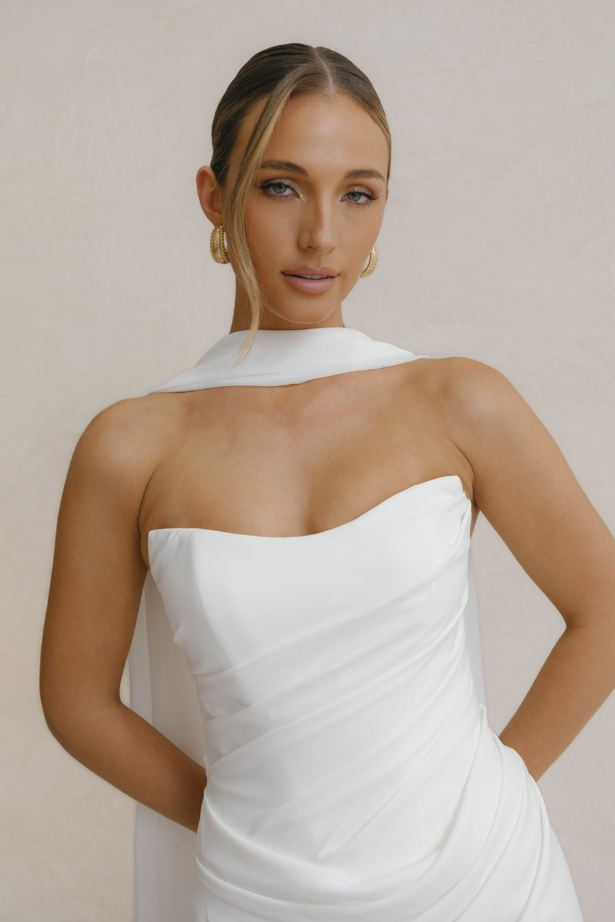 fitted crepe Bridal gown, strapless neckline, drapings around bust and hips. Paired with a scarf 