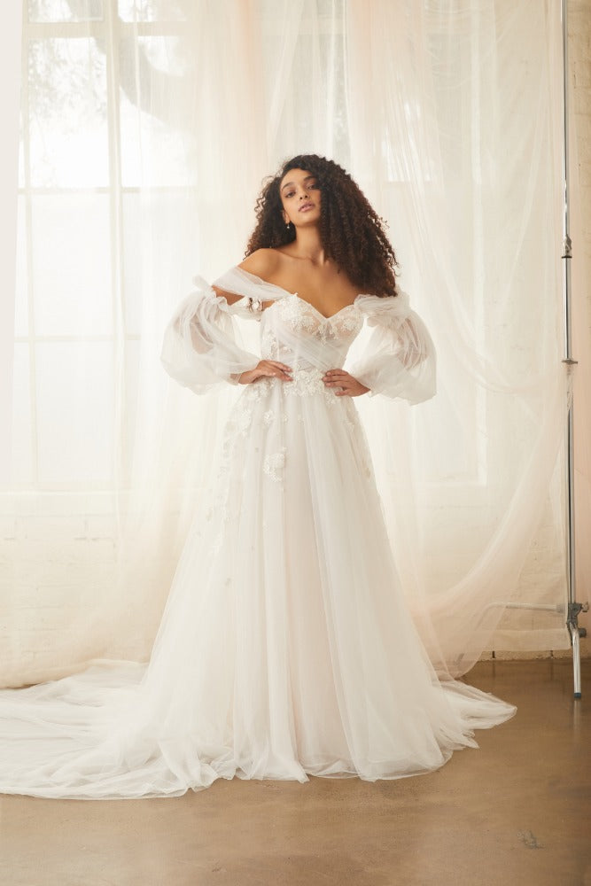 Model wears Sky Gown with detachable Sky Sleeves made from billowing tulle that cinches in the middle of the upper arm. 