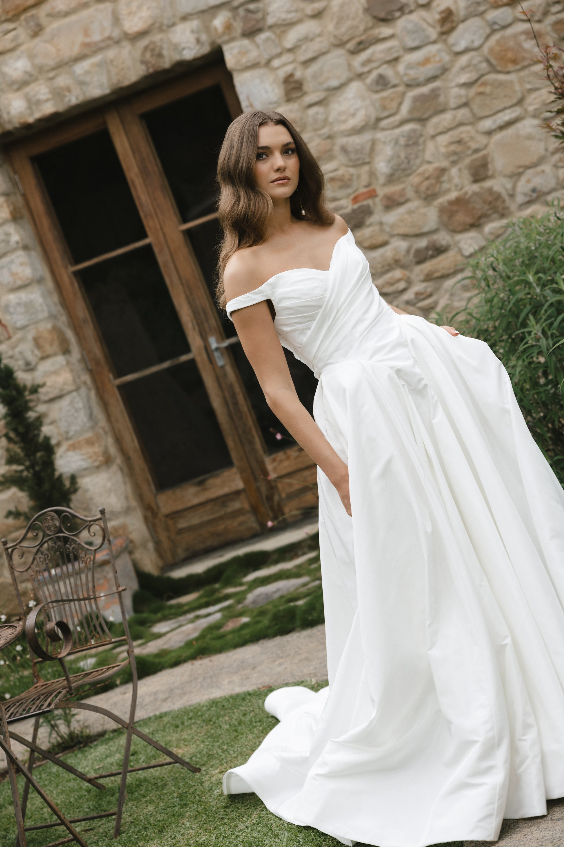 Bridal gown Jodie features a clean A-line silhouette, off-shoulder sweetheart neckline, and basque waistline. Made from Taffeta, it’s designed for a timeless walk down the aisle by Roselle Collection Jessica Couture.