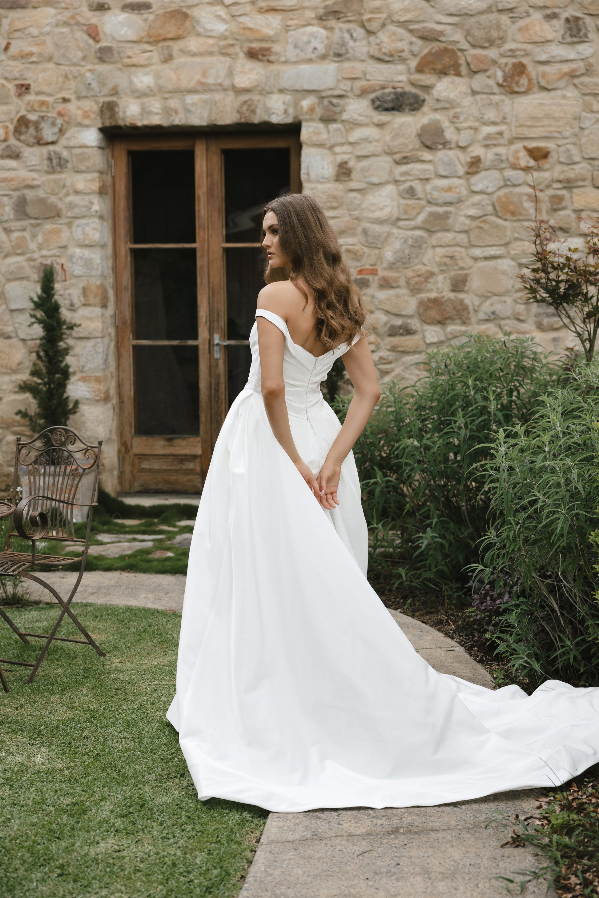 Bridal gown Jodie features a clean A-line silhouette, off-shoulder sweetheart neckline, and basque waistline. Made from Taffeta, it’s designed for a timeless walk down the aisle by Roselle Collection Jessica Couture.