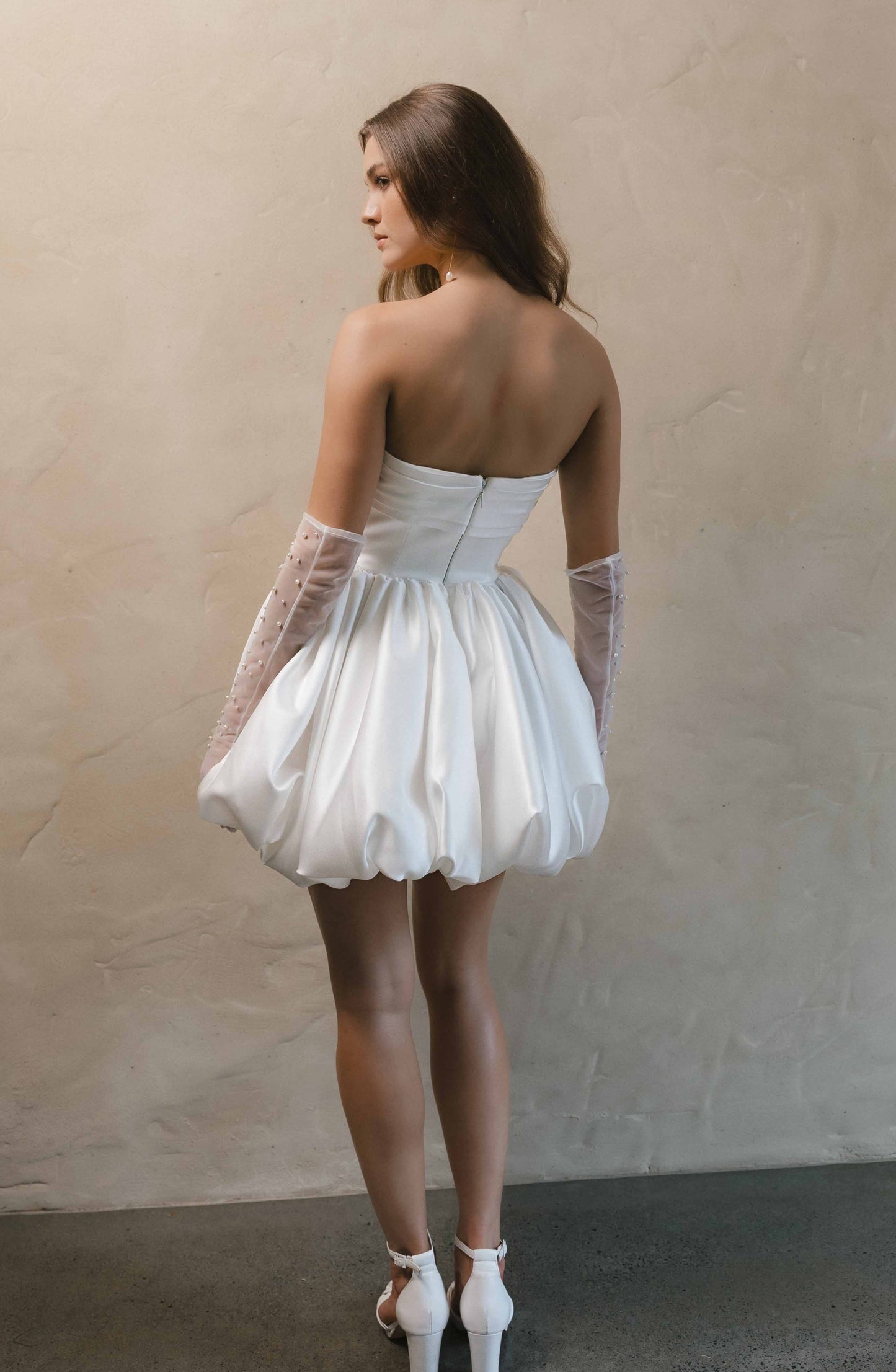 Woman in a white mini dress with pearl top