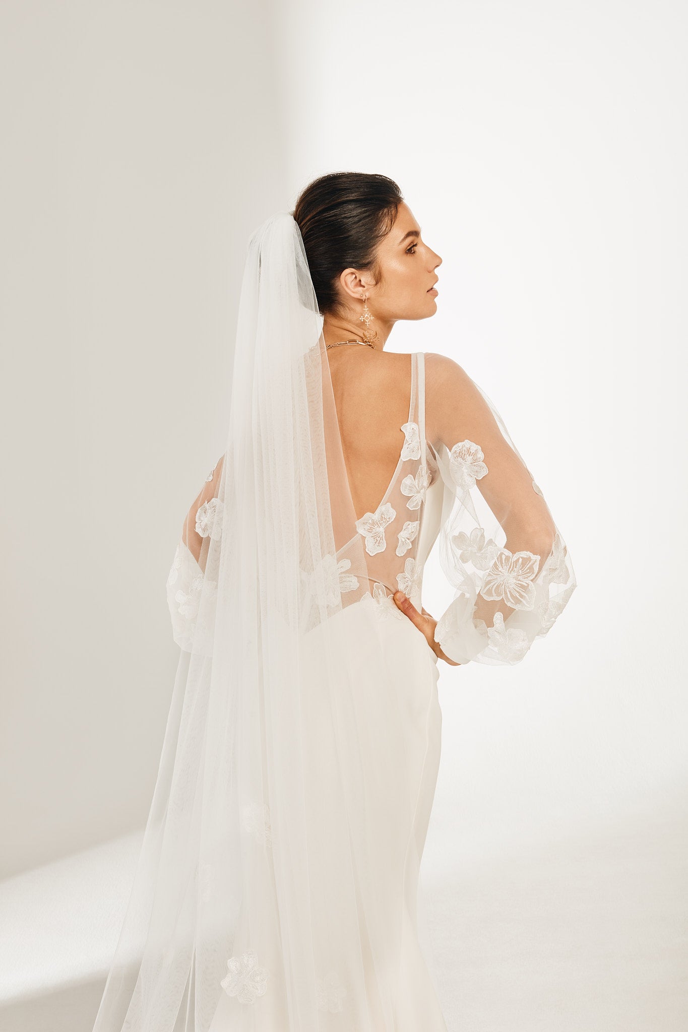 Mid shot of bride in backless dress with tulle Orangina Veil with embroidered flowers