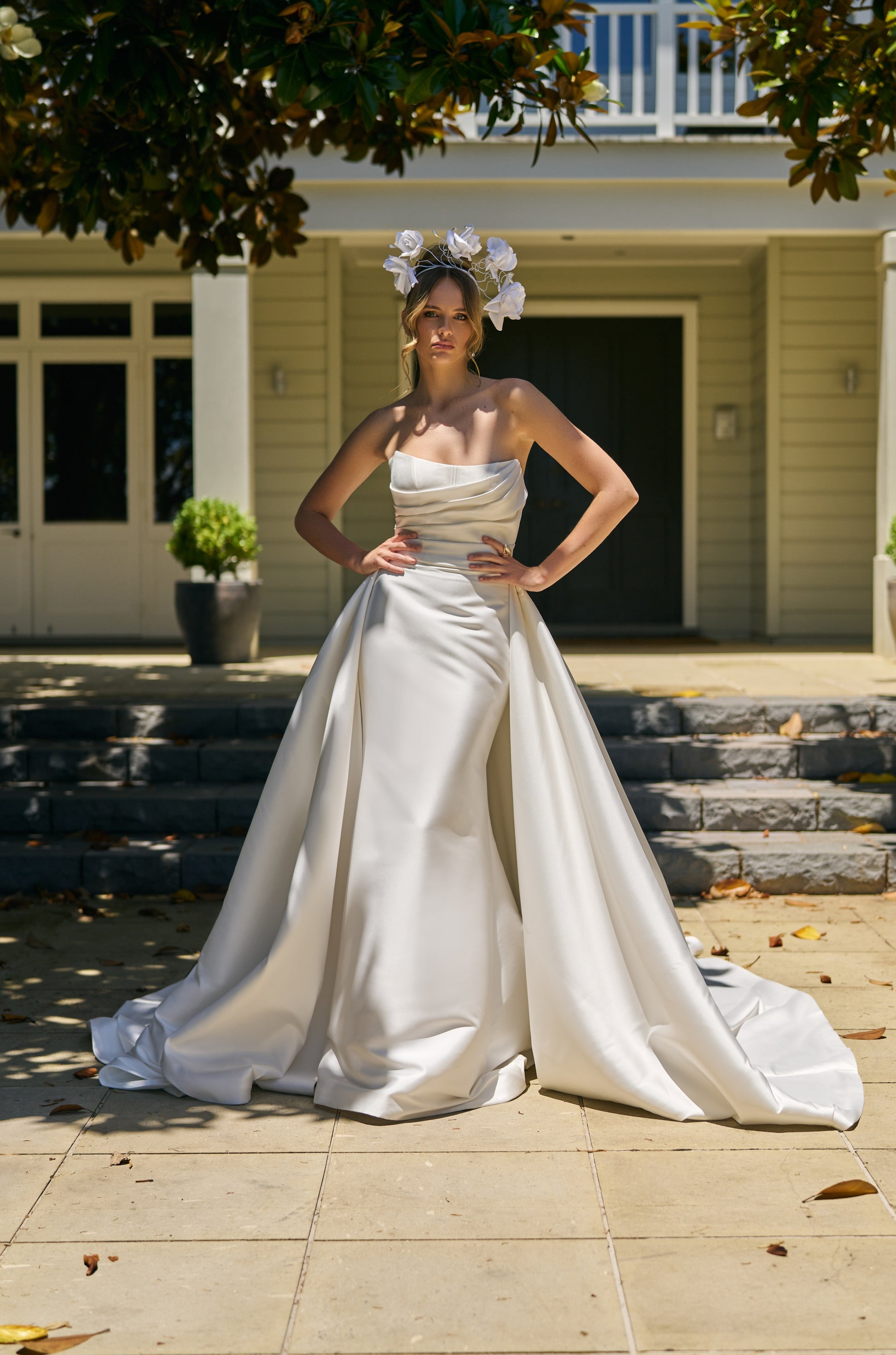 Bride wears Lisha gown with voluminous Lisha Overskirt made from ivory Mikado fabric. Overskirt drops from side seam to side seam, trailing behind. 