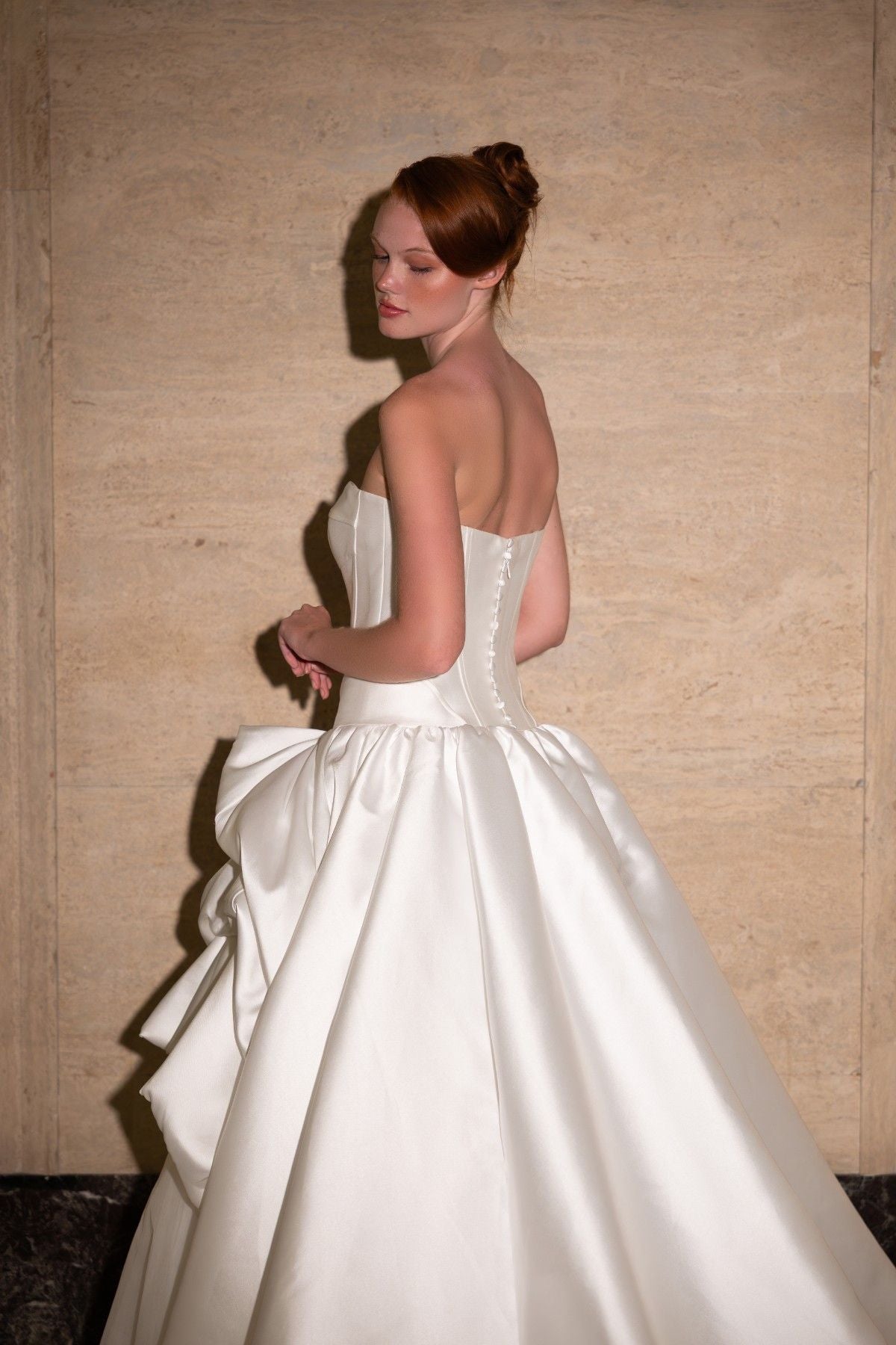 SIDONIE strapless sweetheart mikado ballgown wedding dress with draped pick-up skirt, back three-quarter view of the draped skirt, by Atelier Wu