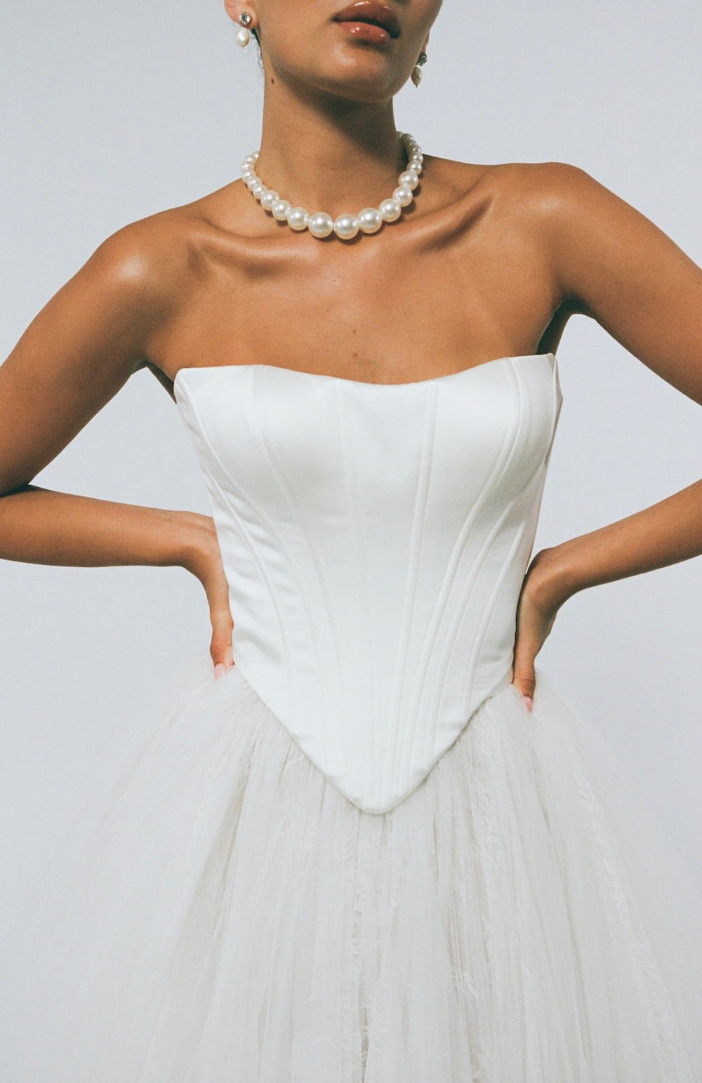 two-piece wedding gown, boned corset top with sharp V basque waist, paired with a pleated voluminous tulle skirt 