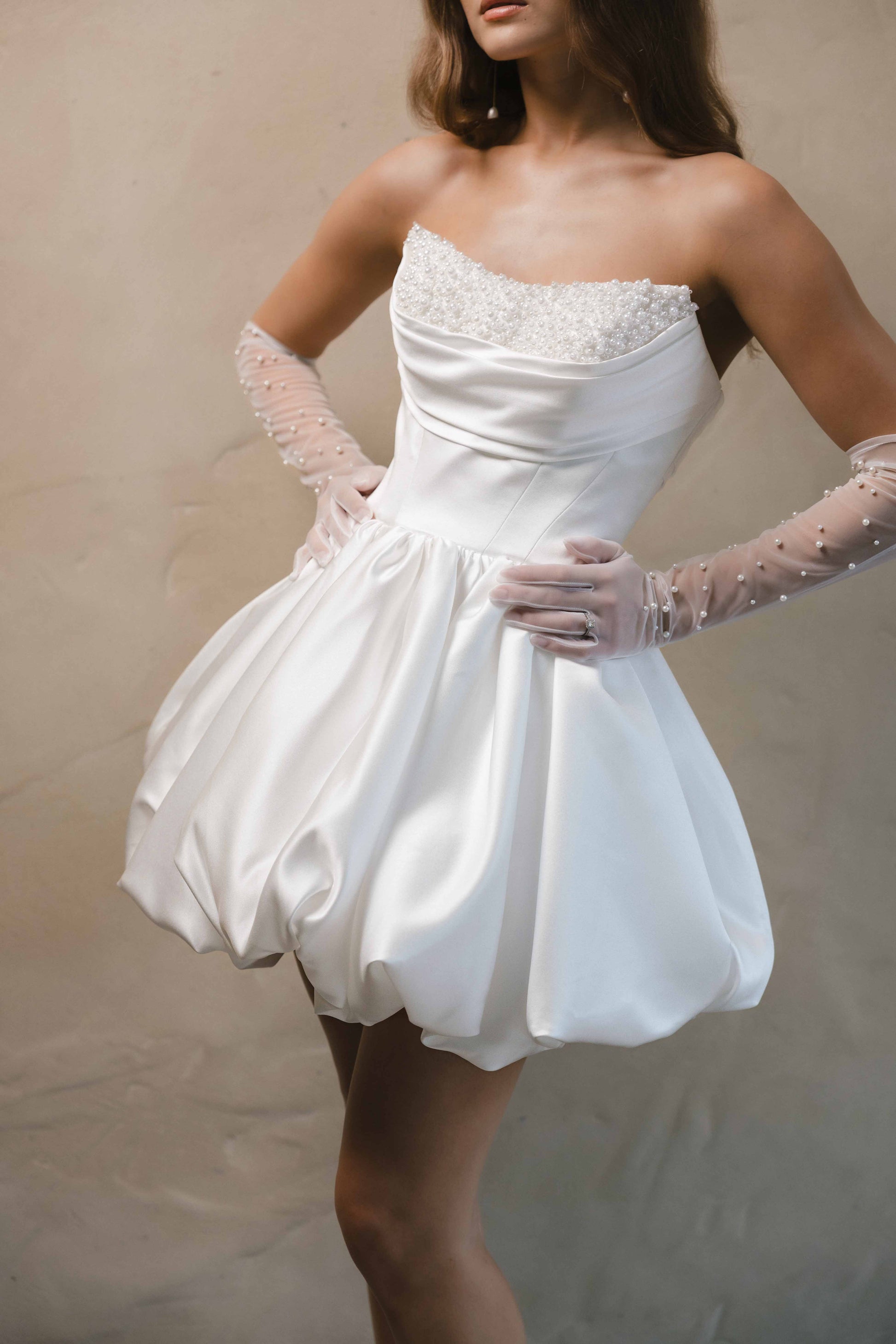 Woman in a white mini dress with pearl top
