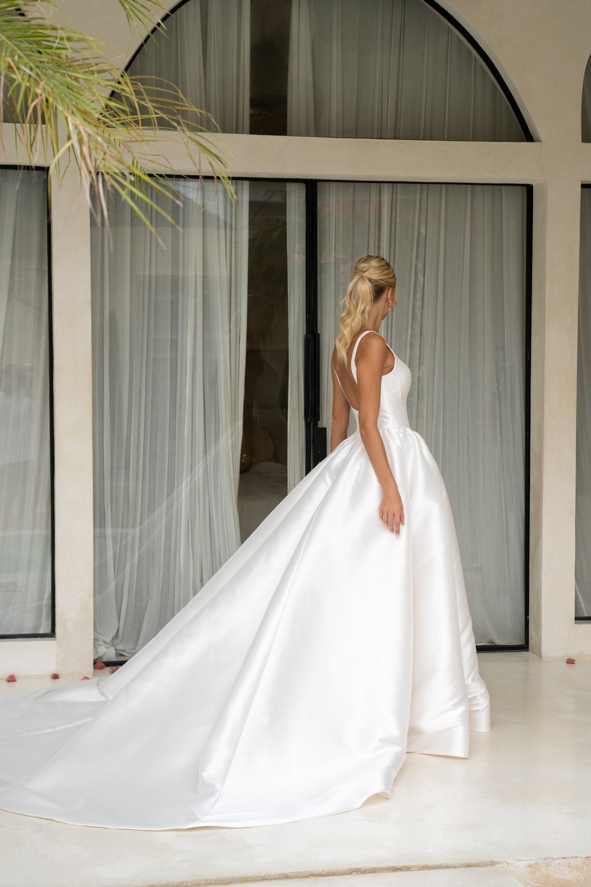Dramatic A-line wedding gown featuring a squared neckline with straps. subtle basque waist with ruching all around waistline. chapel train. 