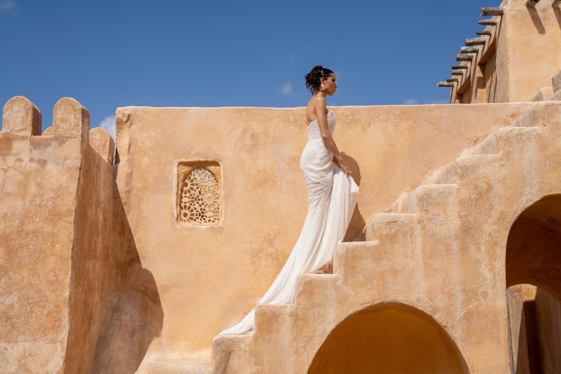 fitted wedding gown with beaded lace, covered in pearls, featuring cat-eye neckline and basque waist. 