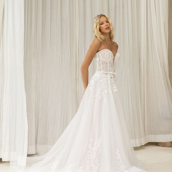 A-line wedding dress with v-plunge sweetheart neckline, floral lace, waistbelt and subtle basque waist, flowing tulle skirt. 