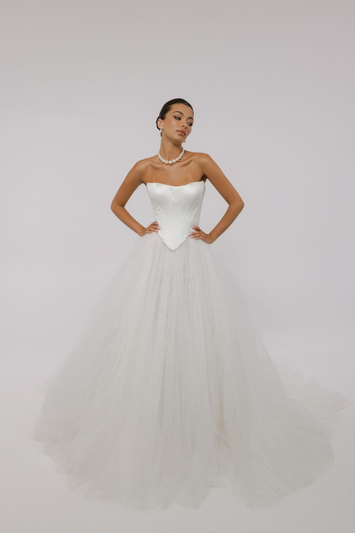 two-piece wedding gown, boned corset top with sharp V basque waist, paired with a pleated voluminous tulle skirt 