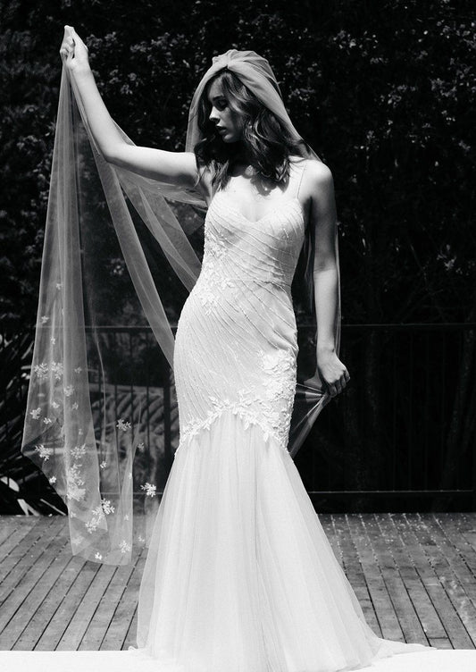 Bride holds Nebraska veil behind her. Veil is soft tulle stitched with 3D flowers