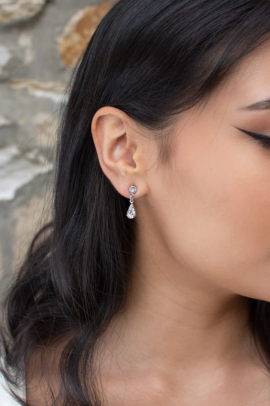 Narrow dangly earring of round and teardrop cubic zirconia.