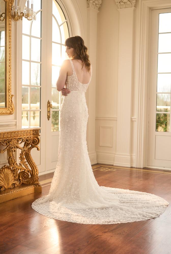 Back view of Kristy. Ivory fit-n-flare wedding gown with delicate 3D florals and beads. Sheer boned corset with plunging backline imitating the square neckline.