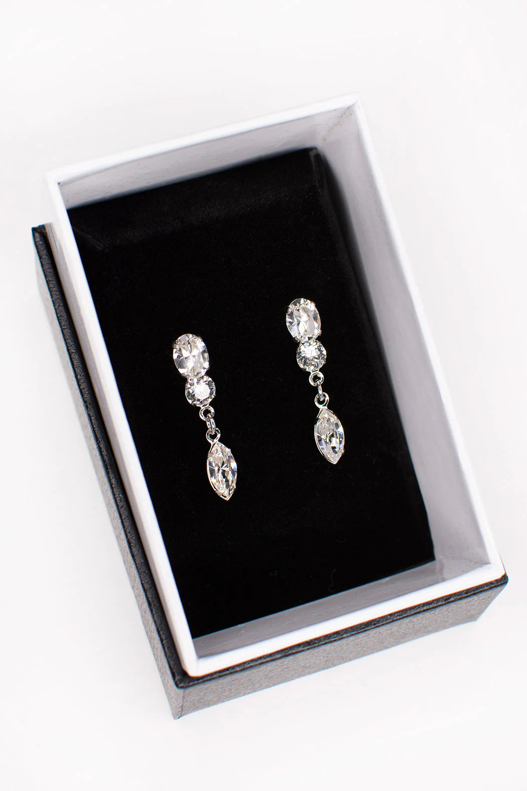 Double cubic zirconia stud earrings with a dangling marquise cut gem