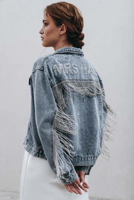 Side view of blue denim jacket with diamante fringe reading 'MRS HALL'