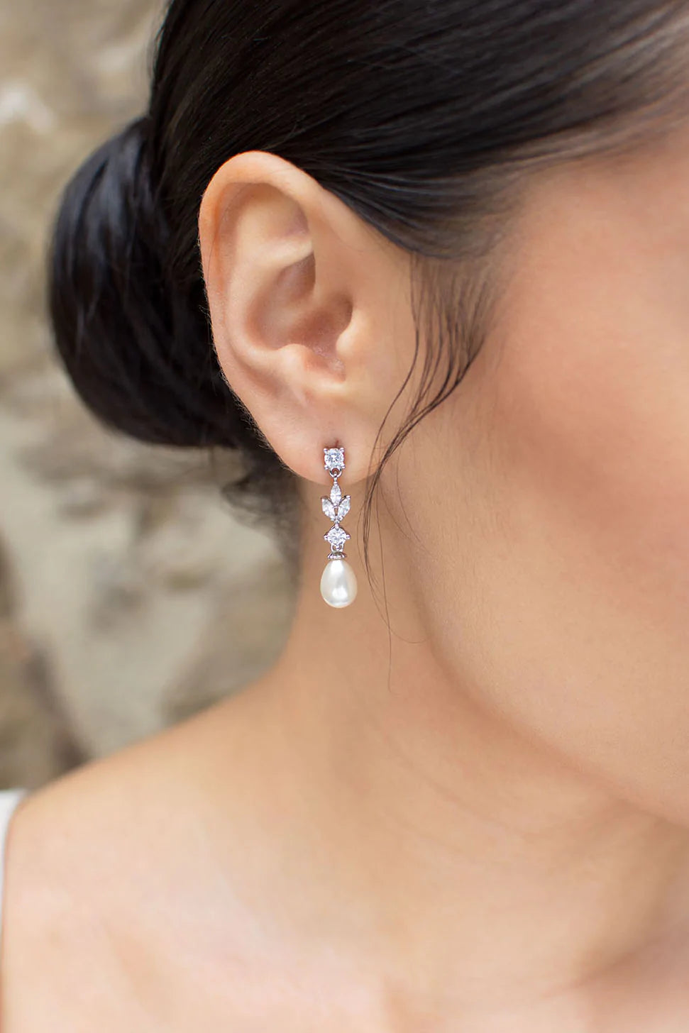 Cubic zirconia dangly earrings with oval shaped pearl at bottom.