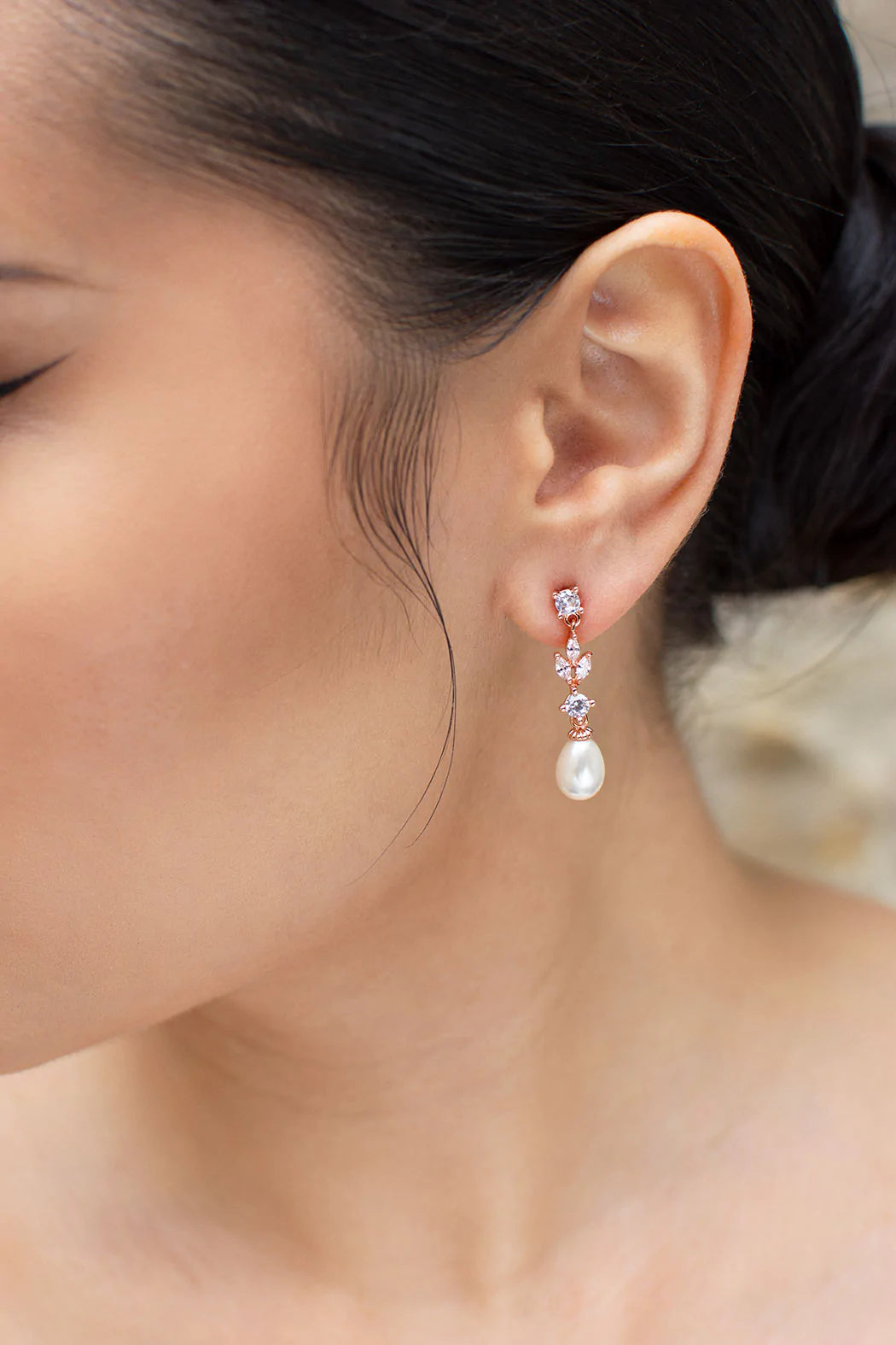 Cubic zirconia rose gold  dangly earrings with oval shaped pearl at bottom.