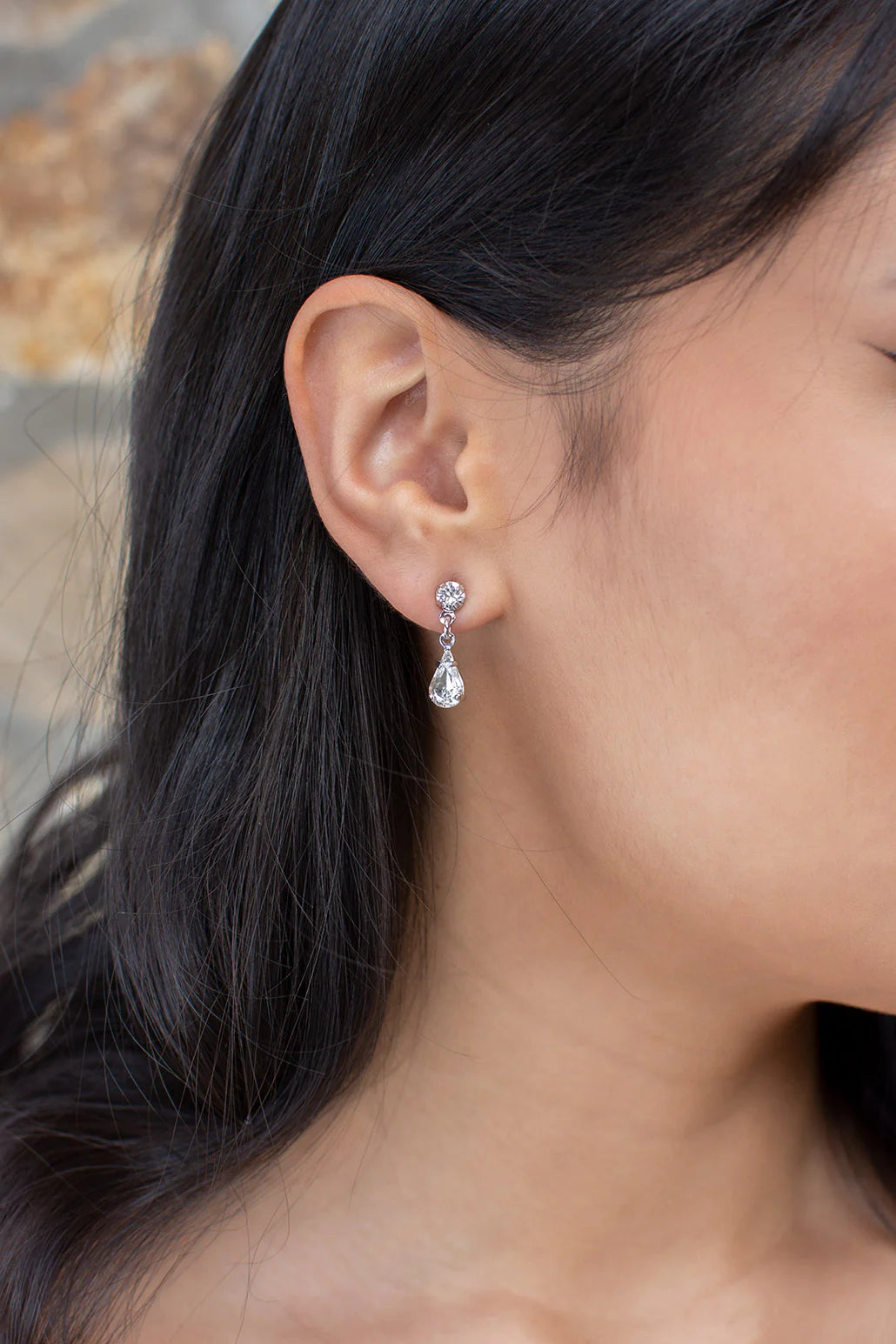 Narrow dangly earring of round and teardrop cubic zirconia.