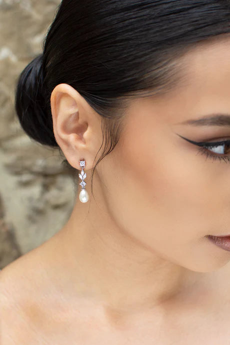 Silver Cubic zirconia dangly earrings with oval shaped pearl at bottom.
